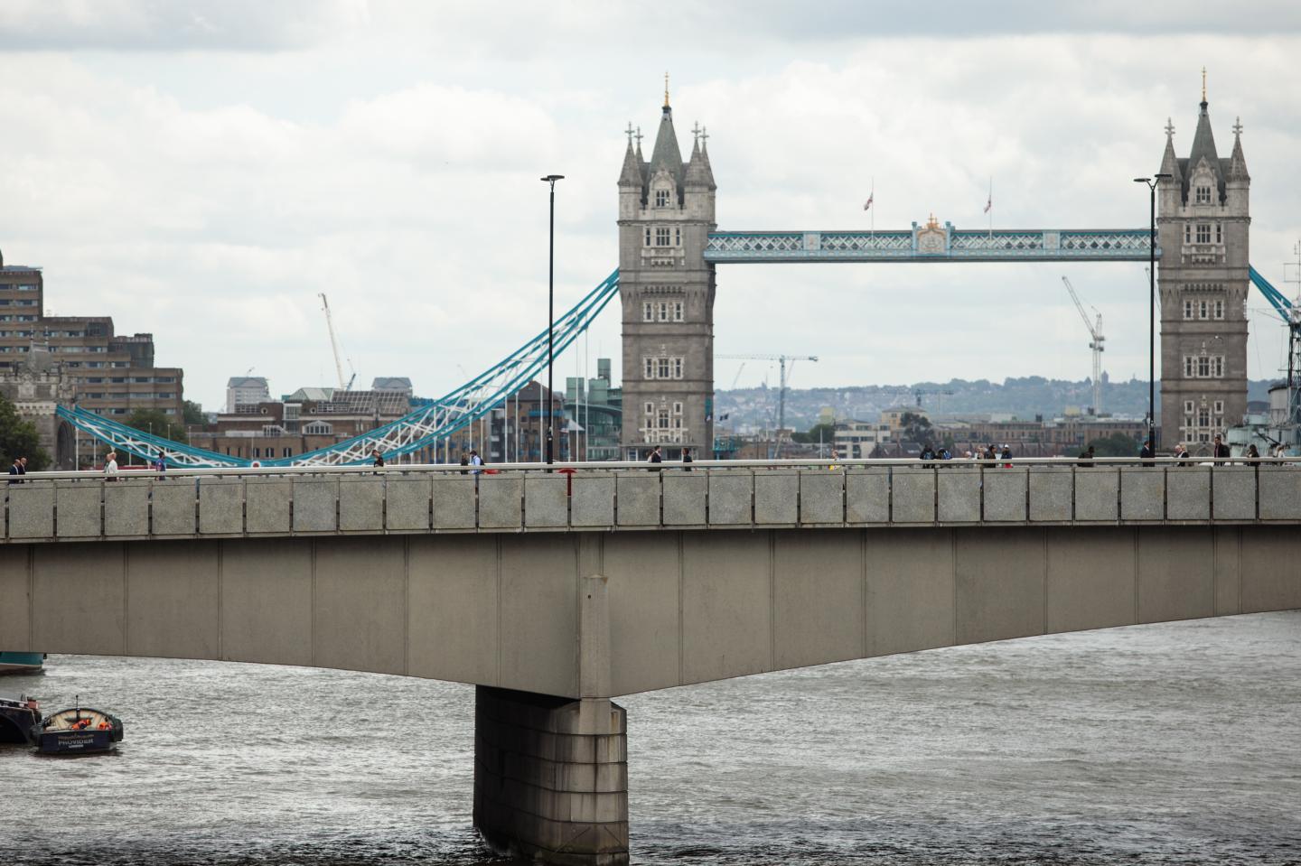 People walk along London Bridge following the June 3rd terror attack on June 5, 2017 in London, England.