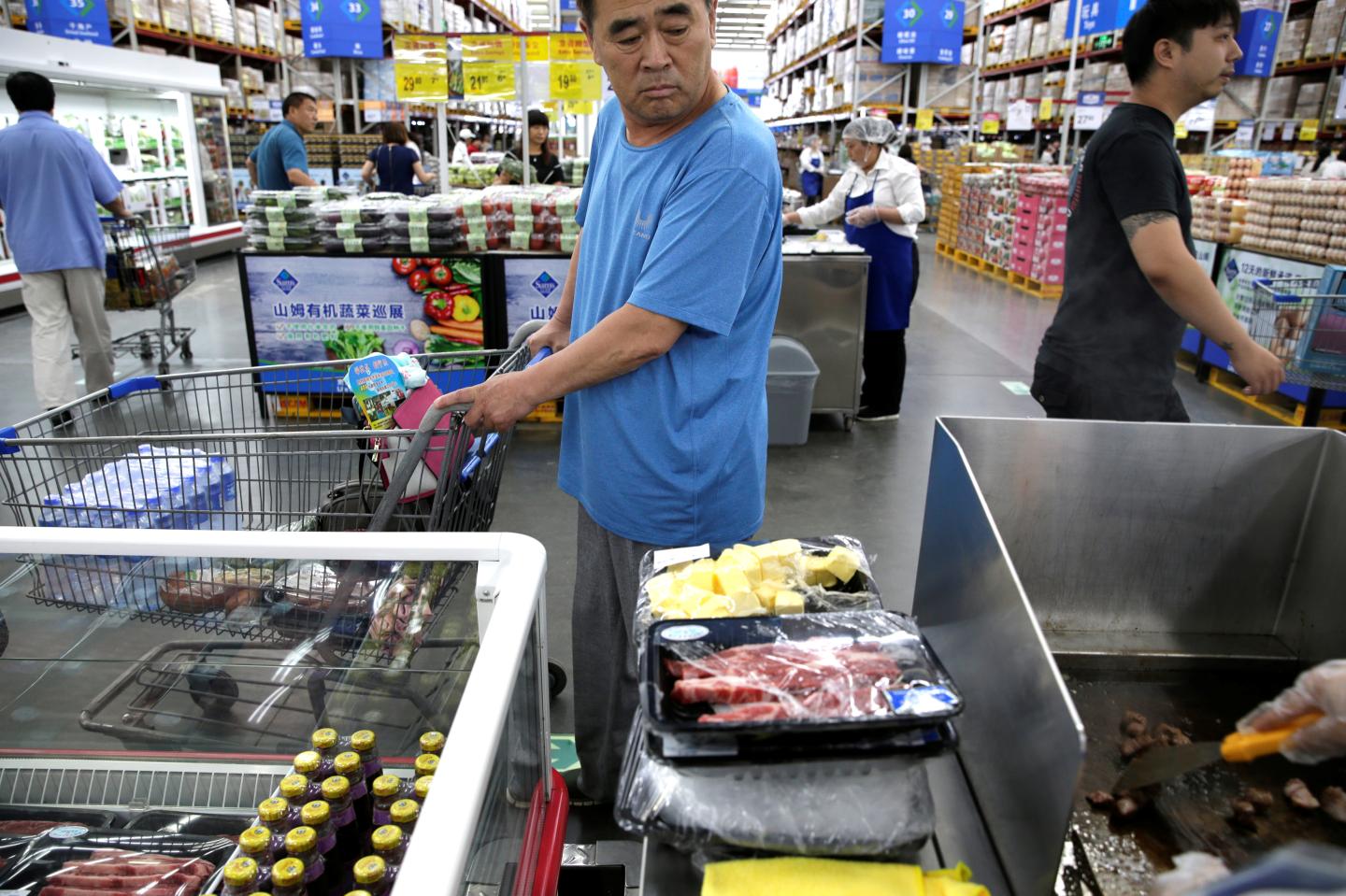 A customer looks at the beef steaks for sale at a Sam's Club store of Wal-Mart in Beijing