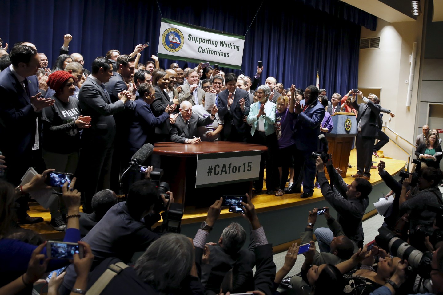 California Governor Jerry Brown signs a bill hiking California's minimum wage to $15 by 2023 in Los Angeles