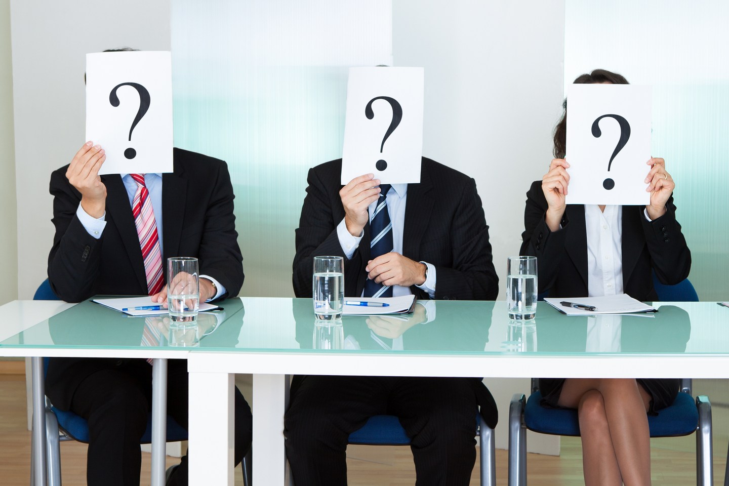 Row of businesspeople with question marks
