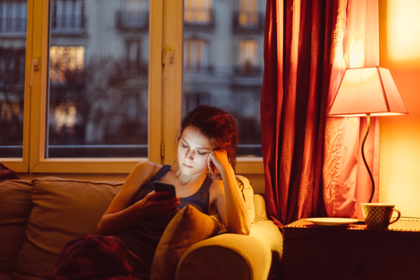 Woman at home texting on phone