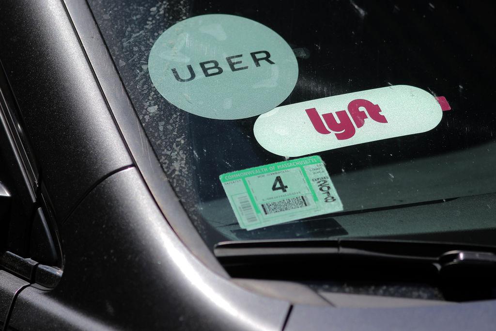 Boston, MA - 06/15/17 -  A driver with placards for both Lyft and Uber waits for a traffic light outside South Station after picking up a passenger.  Will Lyft benefit from the current corporate travails of competitor Uber?   (Lane Turner/Globe Staff) Reporter:  (Adam Vaccaro)  Topic: (16lyft)