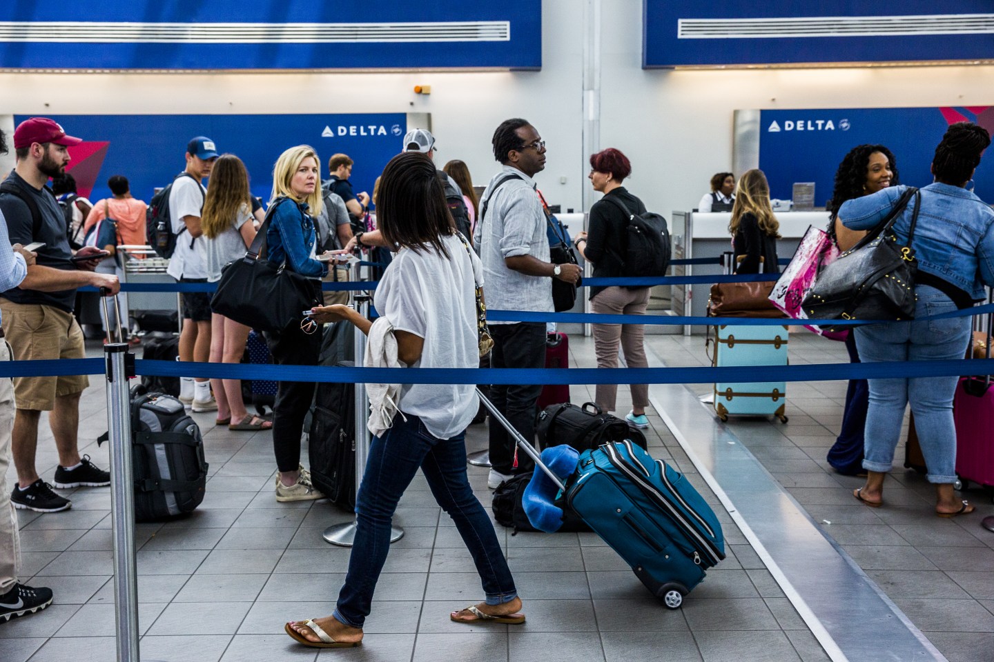 Travelers wait in line at the Delta Air Lines ticket counter inside LaGuardia Airport (LGA) in New York, U.S., on Thursday, June 29, 2017.