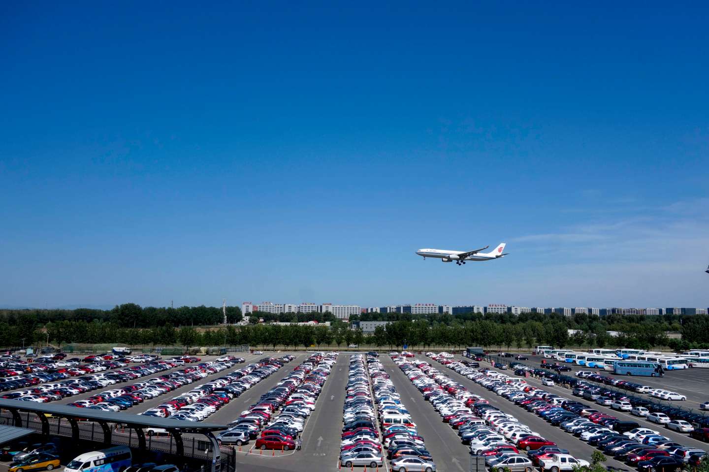 A plane of Air China flies over a parking lot as it cones in