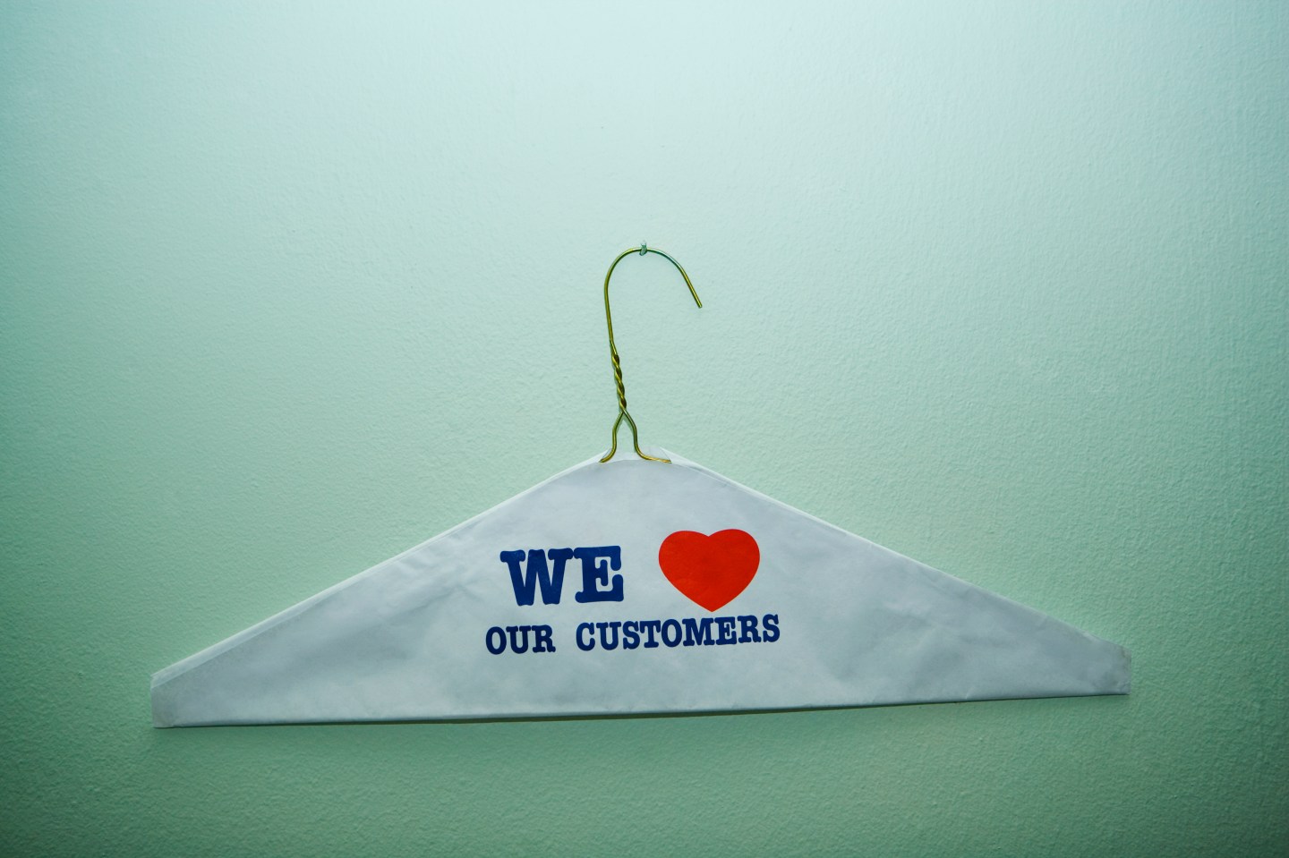 Close-up of text We Love Our Customer painted on a cloth on a hanger, New York City, New York State, USA