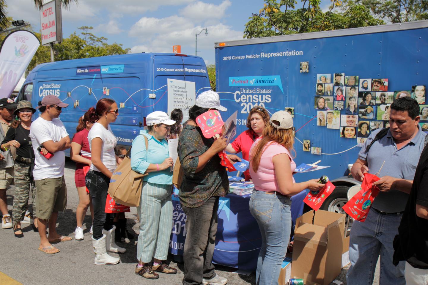 Men and women queuing at Carnaval Miami passing the Census 2010 information stand.