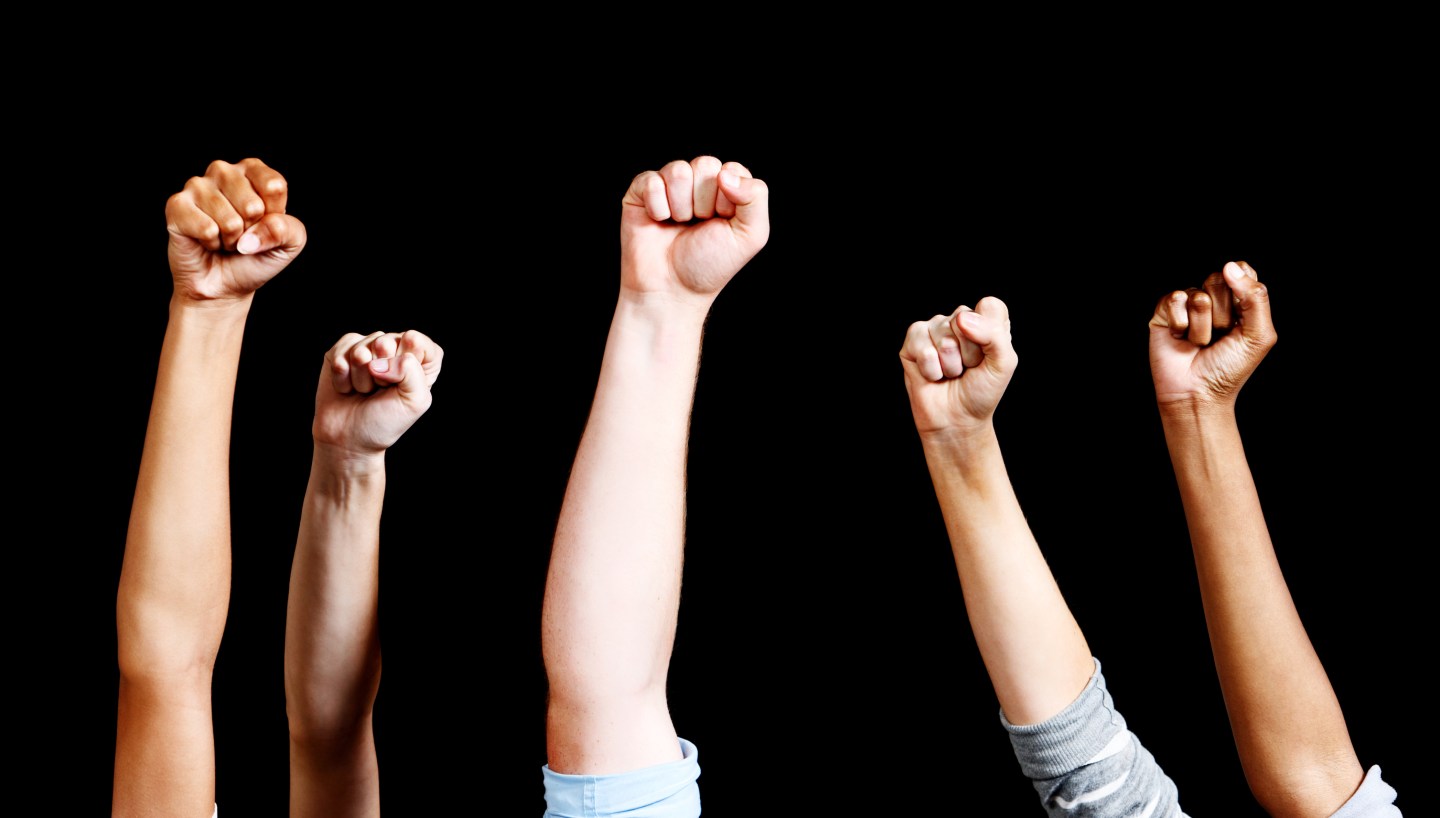 Five mixed air-punching fists against black