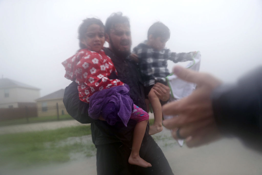HOUSTON, TX - AUGUST 28: Rescuers help a man and children from flooding from Hurricane Harvey on August 28, 2017 in Houston, Texas. Harvey, which made landfall north of Corpus Christi late Friday evening, is expected to dump upwards to 40 inches of rain in Texas over the next couple of days. (Photo by Joe Raedle/Getty Images)