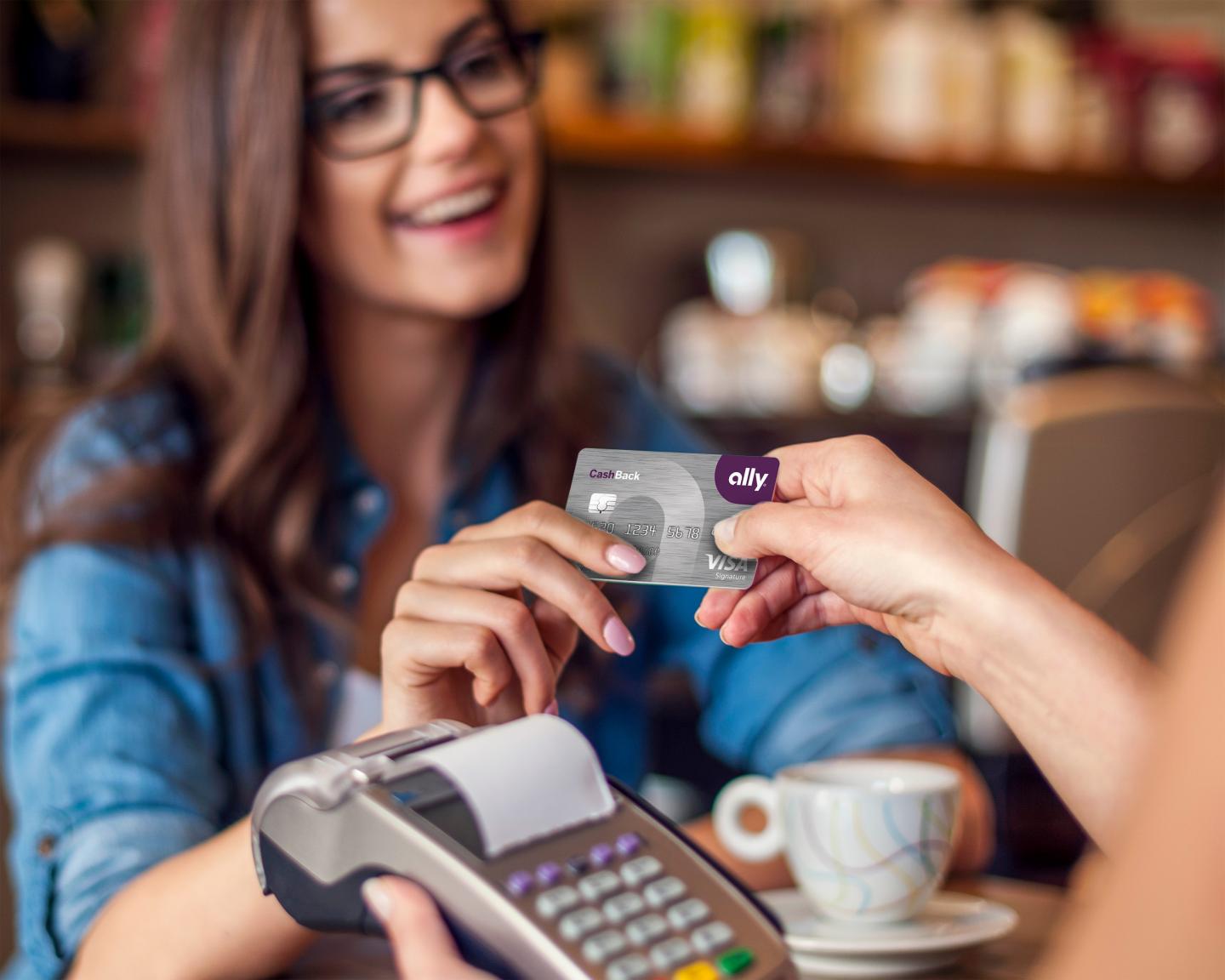 Happy woman paying for cafe by credit card