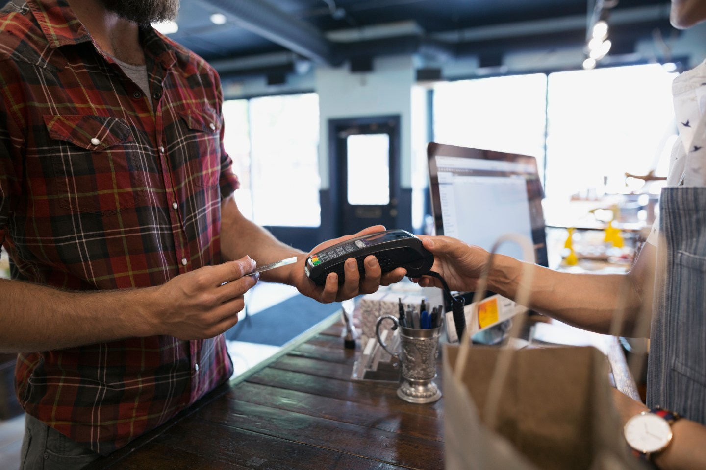 Man paying with credit card reader in shop