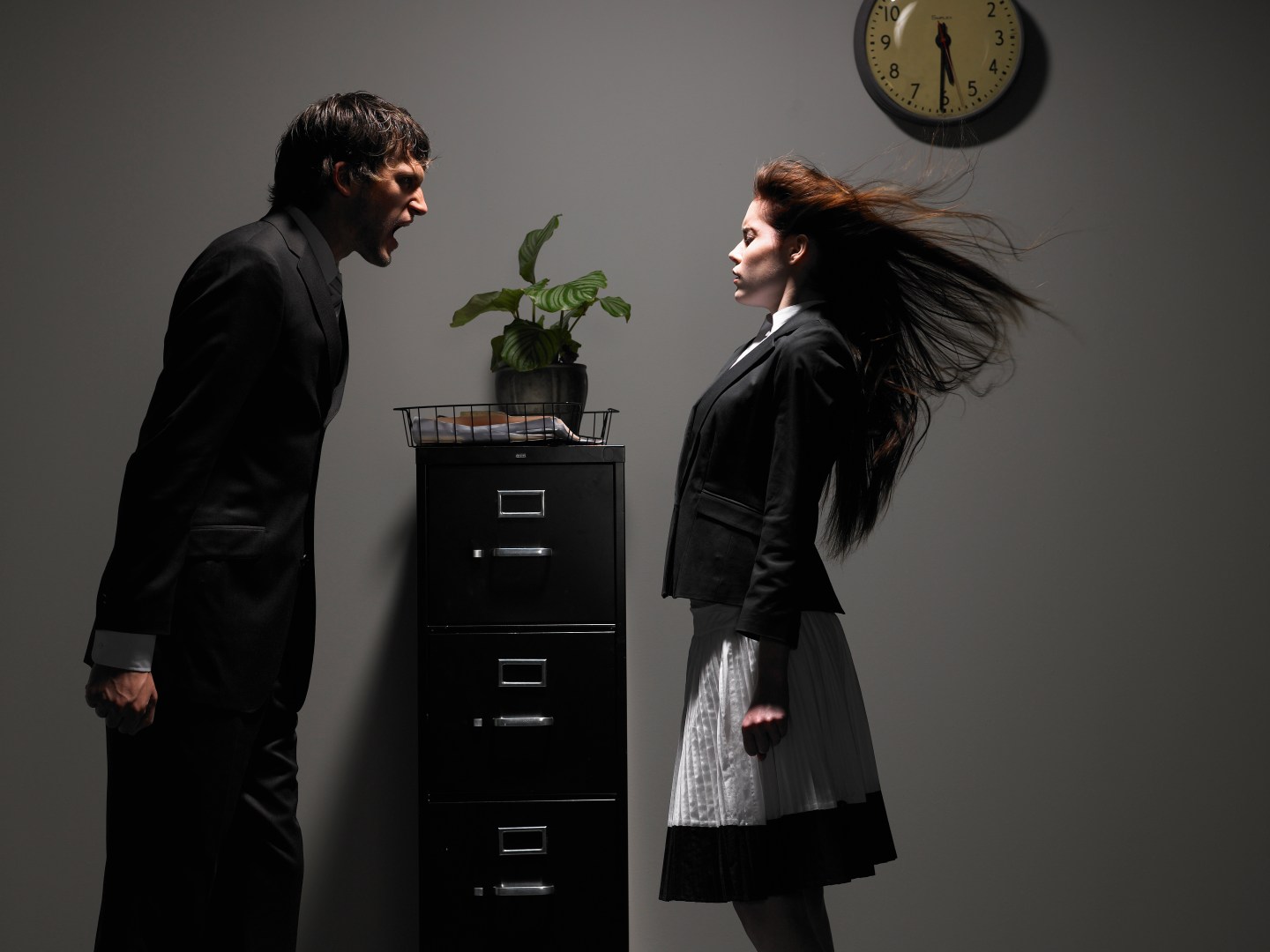 Young male and female office workers standing by archive, man yelling