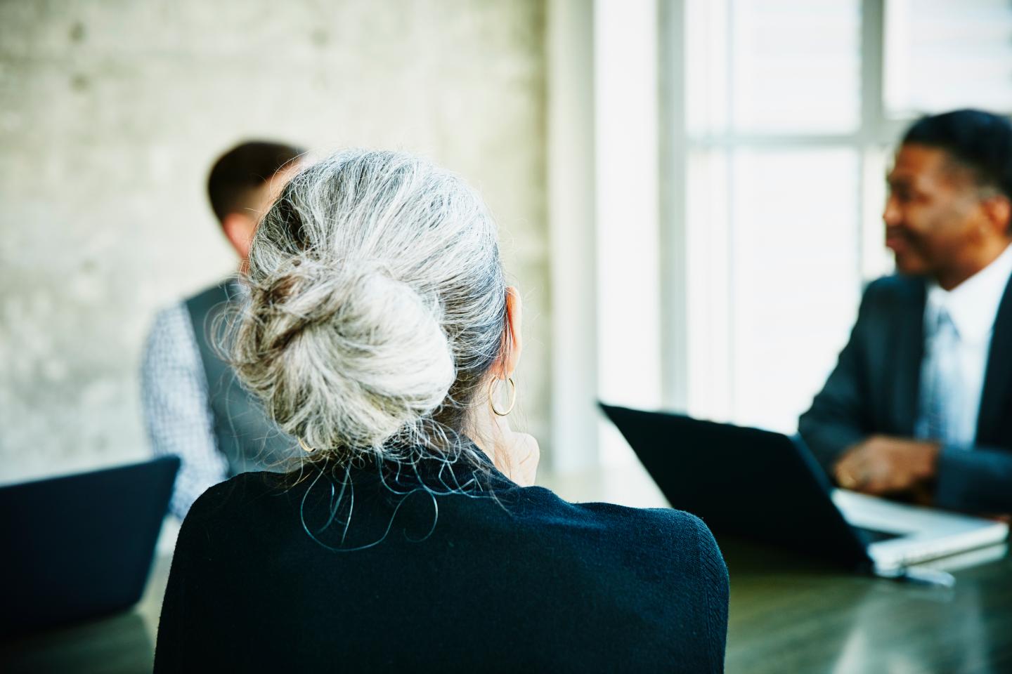 Mature businesswoman listening during meeting