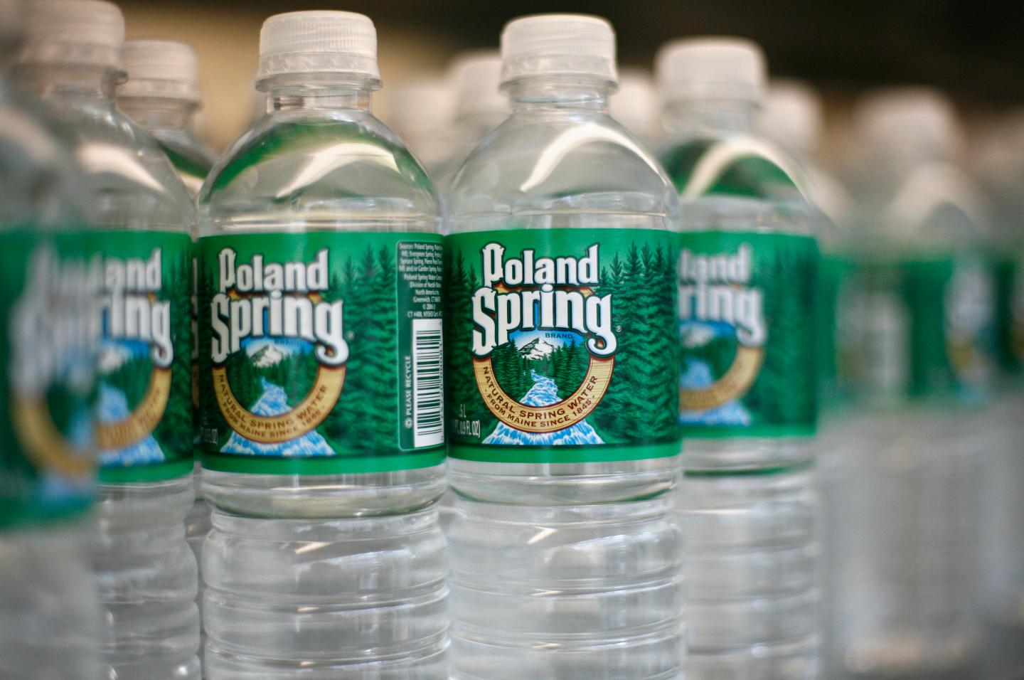 Bottles of Poland Spring water, are arranged on a shelf in N