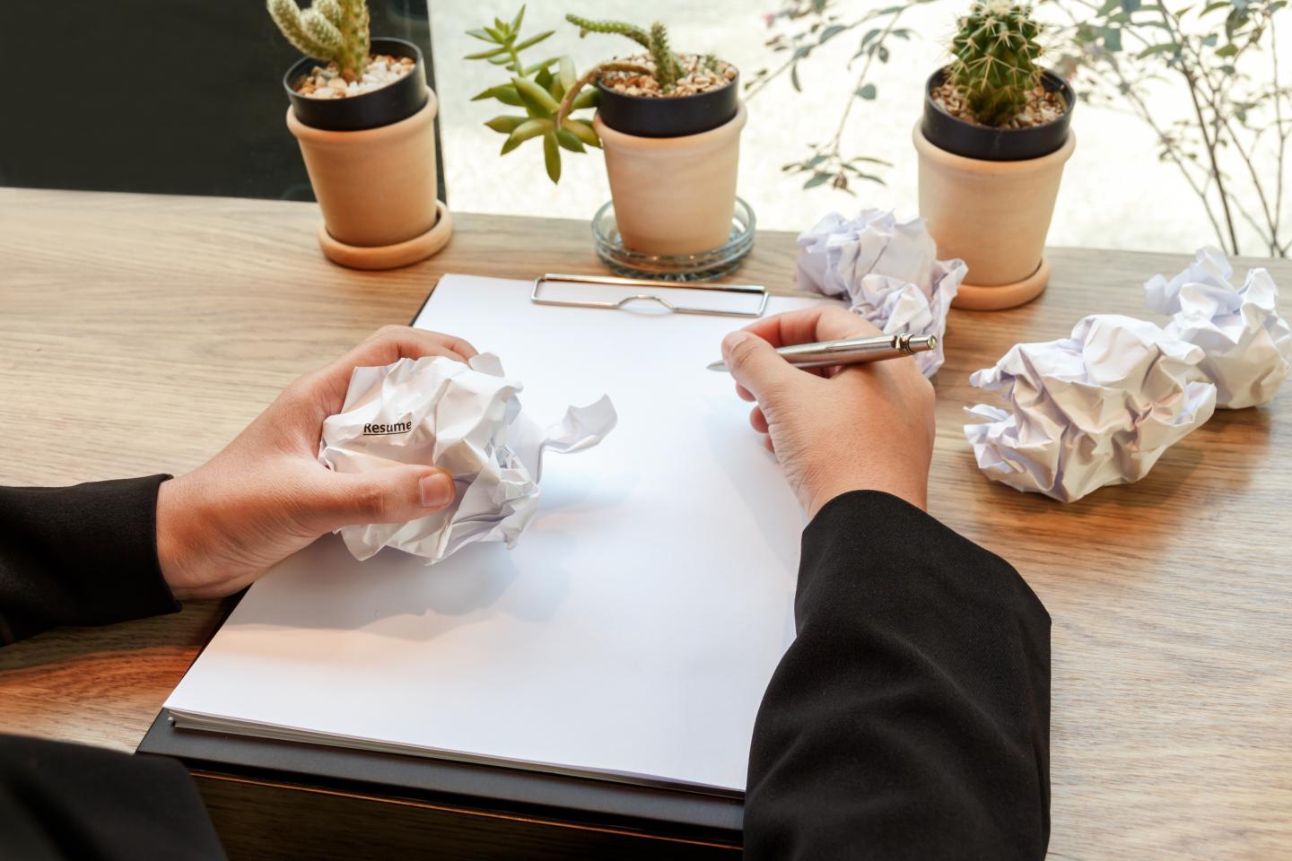 Hands of business woman crumple resume at the desk, mistake document - failure business concept.