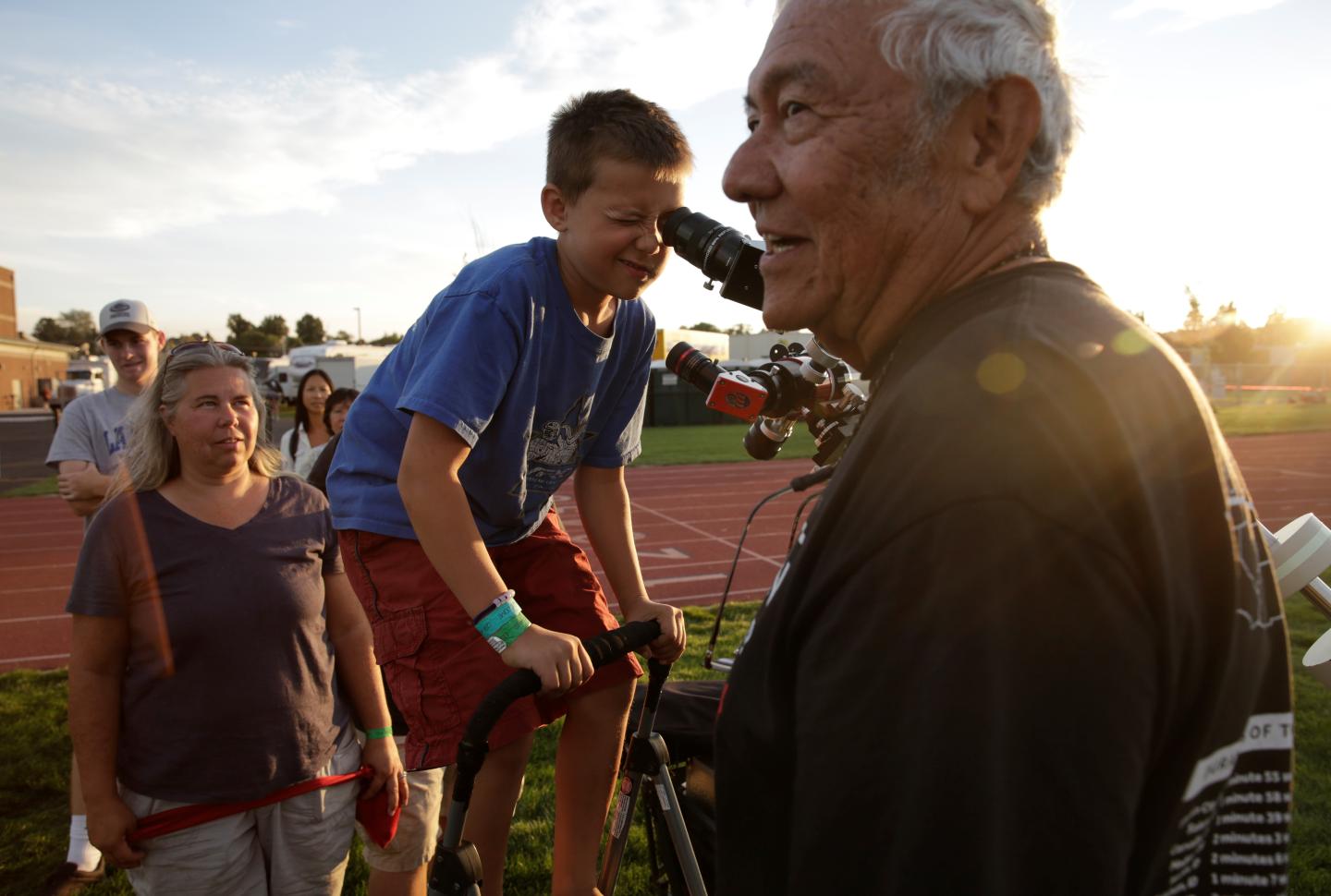 Ken Spencer of Buckeye, Arizona, assists people as they look at the sun through a solar filter-equipped telescope at the Lowell Observatory Solar Eclipse Experience in Madras