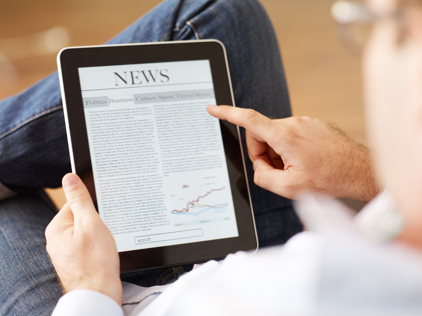 Man reading the newspaper on digital tablet