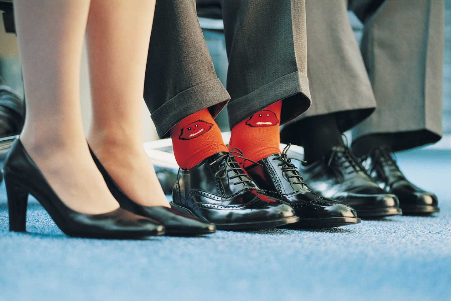 Businessman Wearing Individualistic Socks Between Two of His Colleagues
