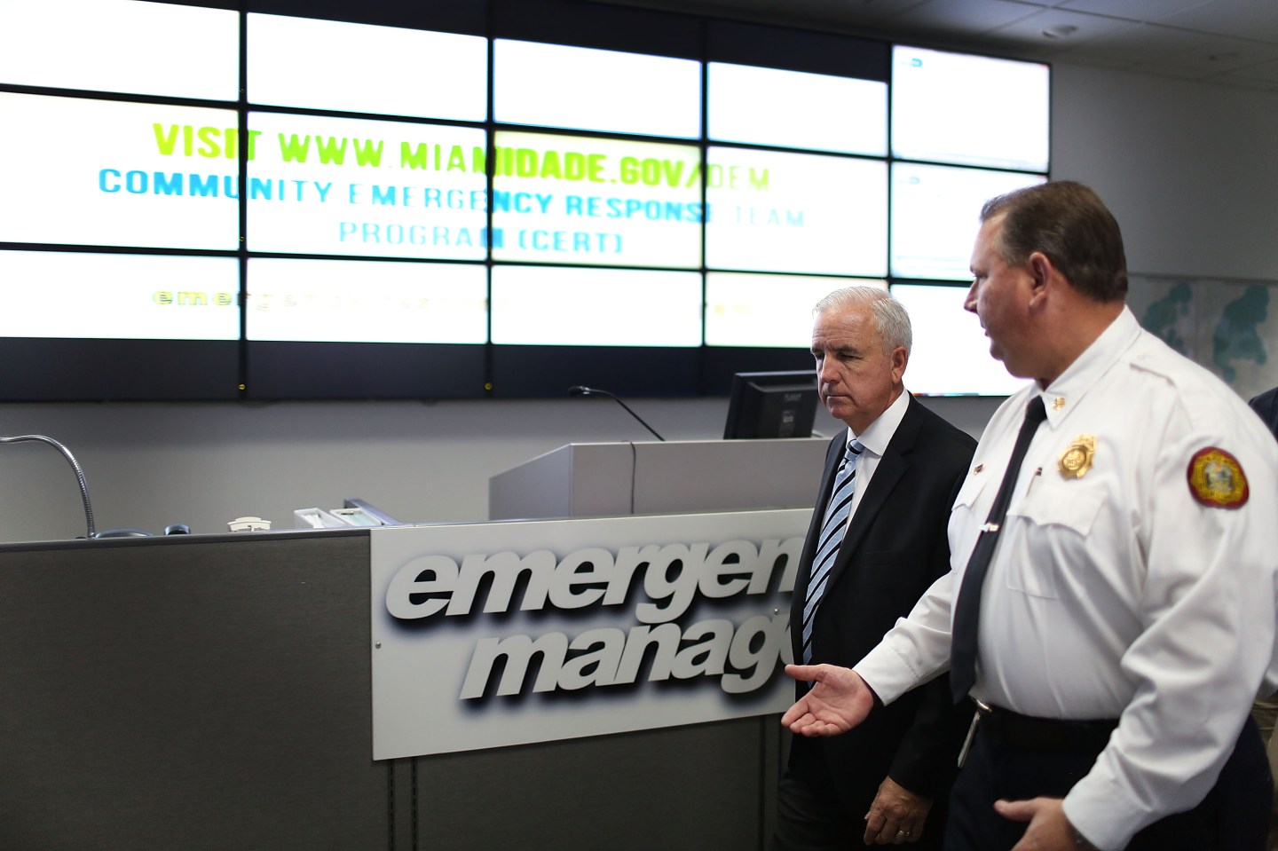 Miami-Dade County Mayor Carlos A. Gimenez (L) walks with Fire Chief Dave Downey of the Miami-Dade Fire Rescue Department.