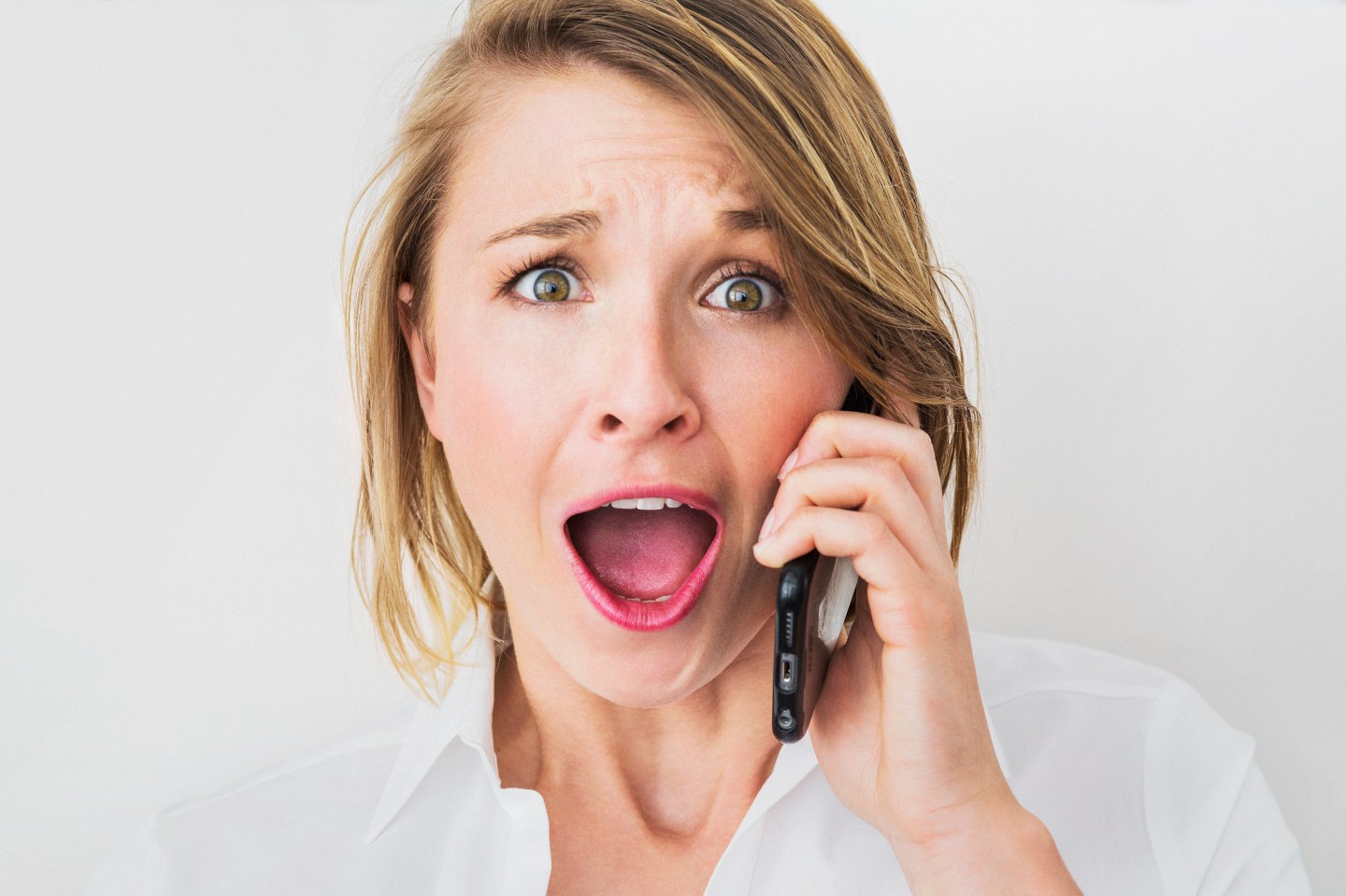 Young woman on cell phone, surprised expression