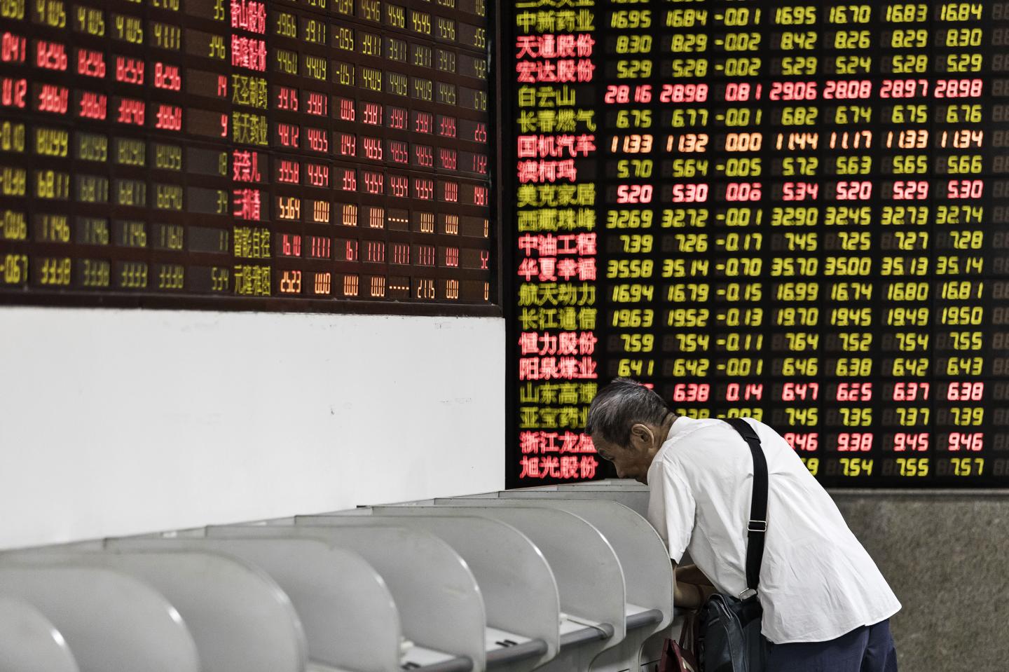 Investors Watch Stock Boards At A Security Firm
