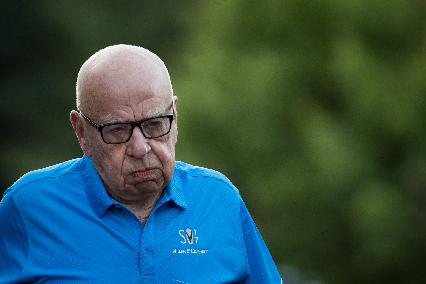 Rupert Murdoch, chairman and CEO of News Corp, looks exasperated while walking outside