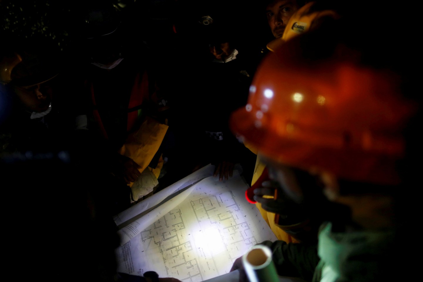 Rescue worker and Mexican soldiers study the drawing of a collapsed building as they search for survivors after an earthquake in Mexico City
