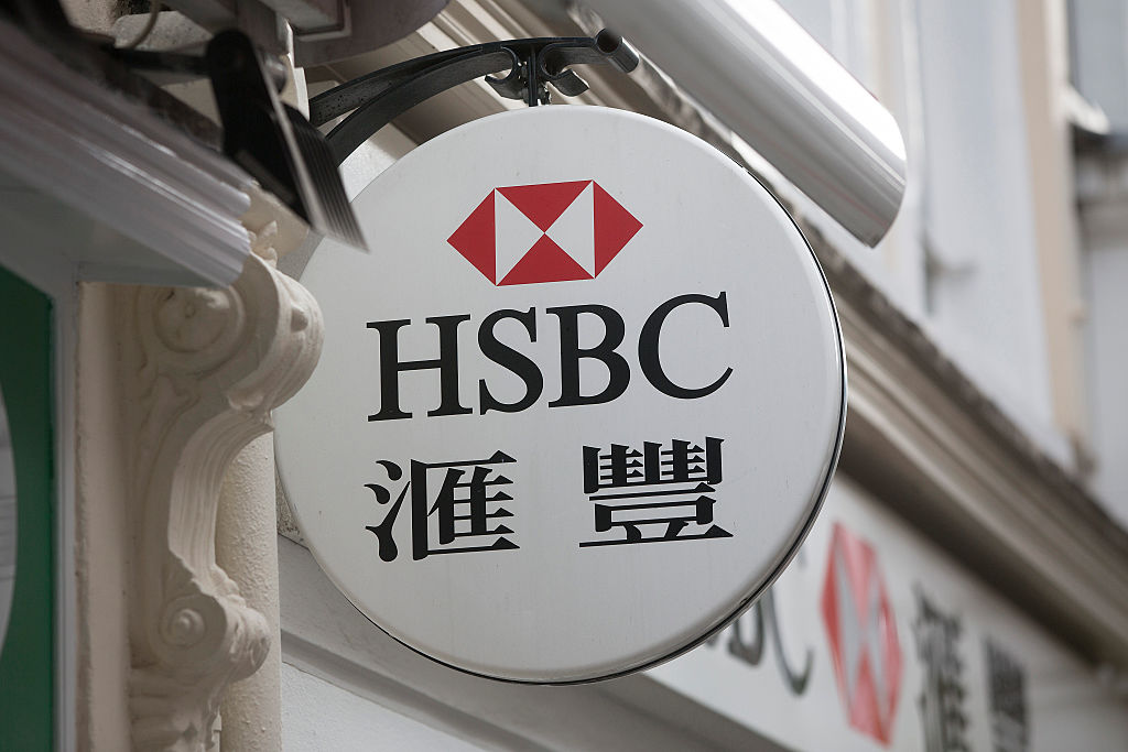An HSBC logo with Chinese characters sits on display outside an HSBC Holdings Plc bank branch in London, U.K., on Tuesday, June 9, 2015. HSBC will eliminate as many as 50,000 jobs through 2017 by shrinking its global reach as Chief Executive Officer Stuart Gulliver seeks to cut annual costs by about $5 billion to restore profit growth. Photographer: Simon Dawson/Bloomberg