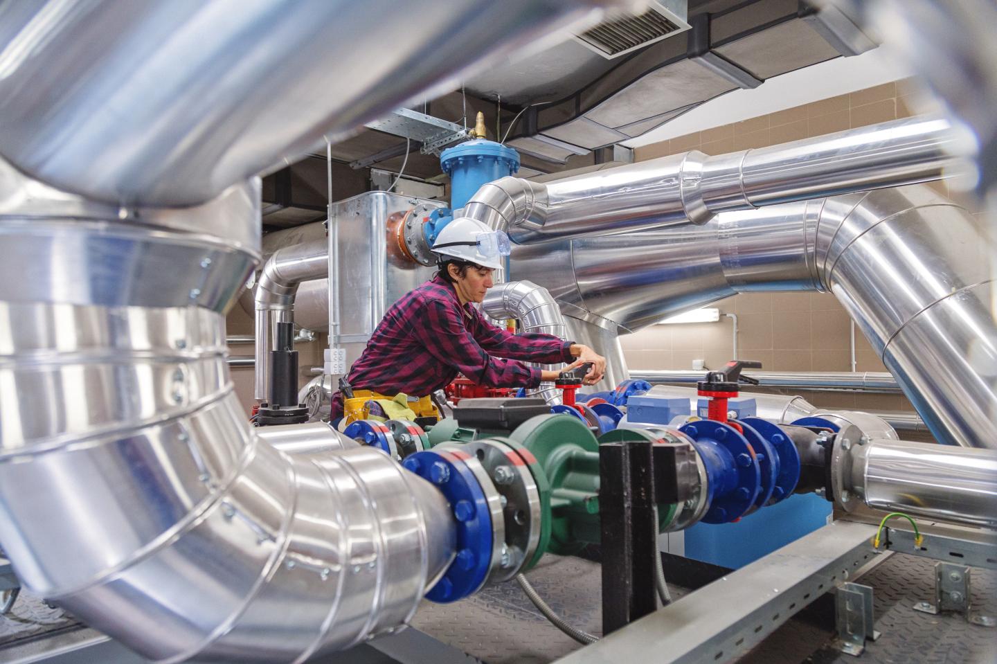 Technician working on valve in factory or utility