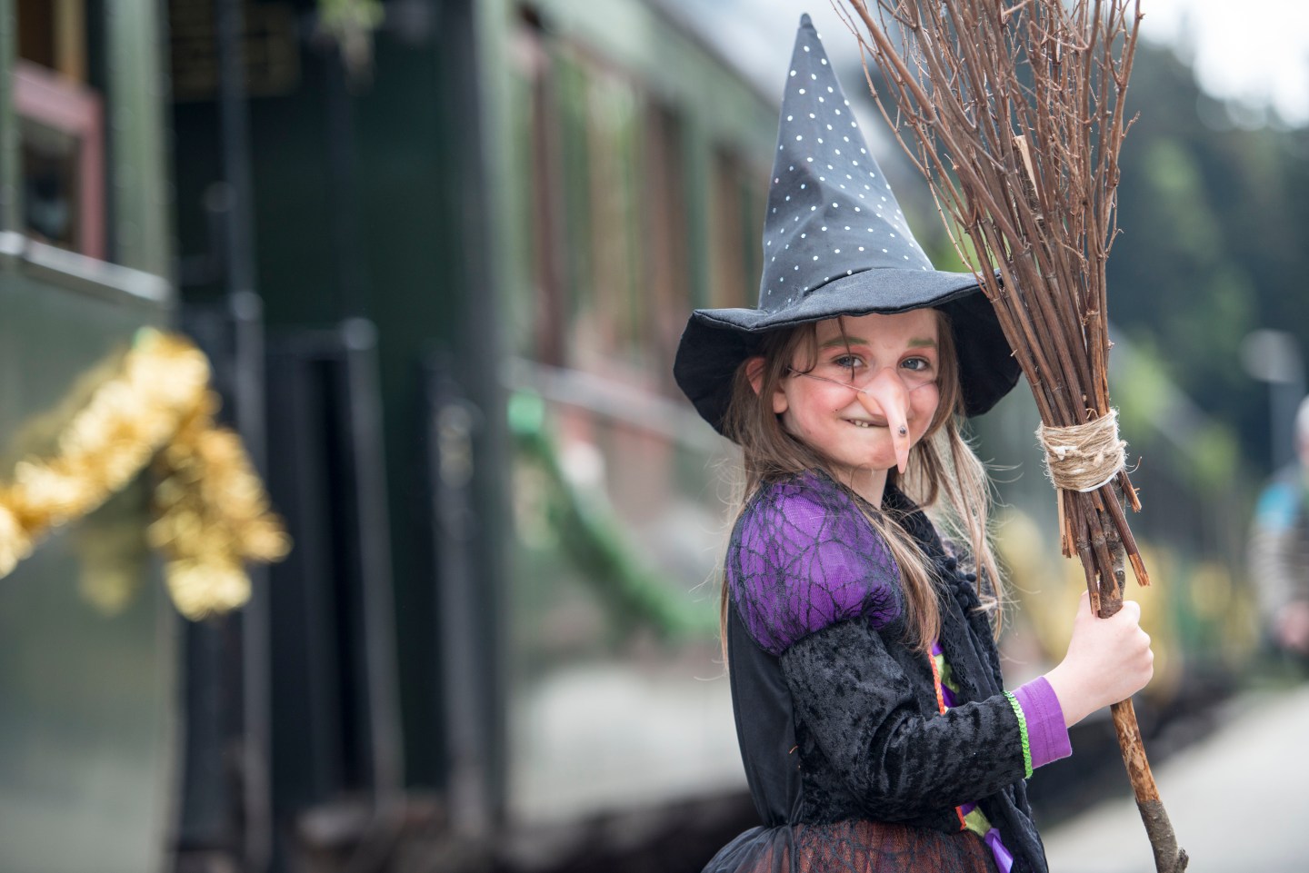 A little girl wearing a Halloween witch costume