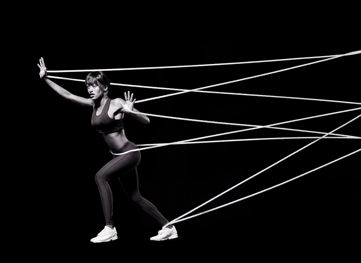 Female athlete pushing against ropes