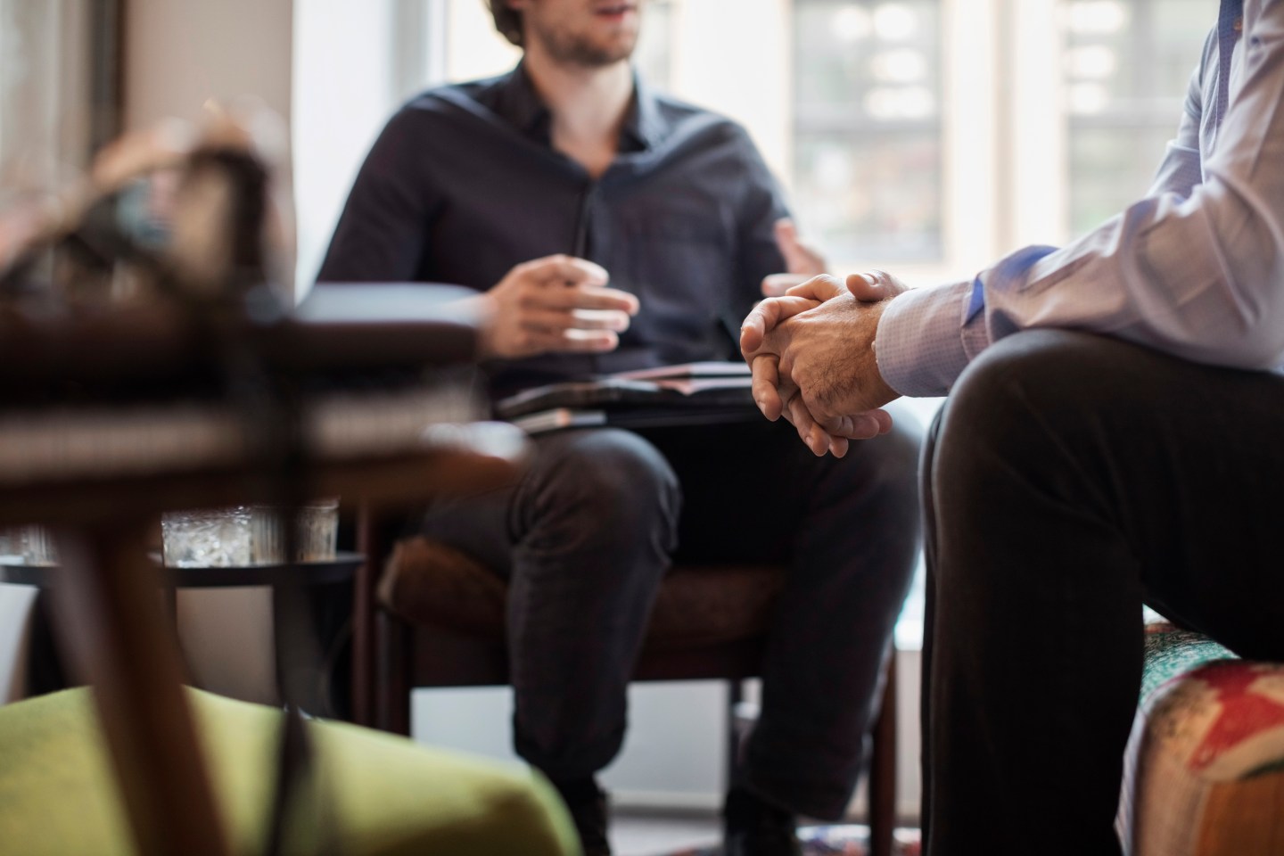 Midsection of businessmen discussing while sitting in office