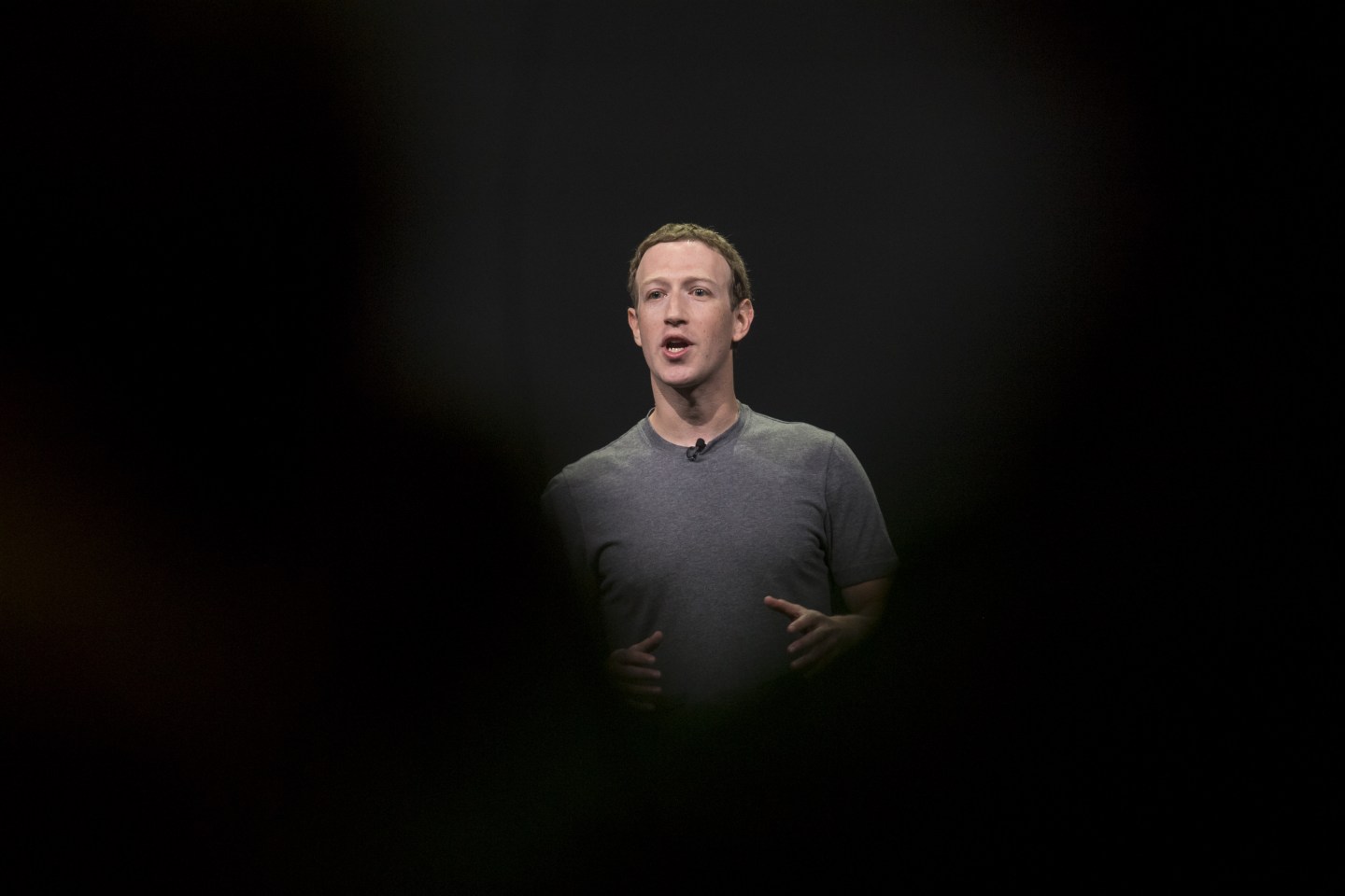 Mark Zuckerberg speaks at a tech conference, in the middle of shadows.