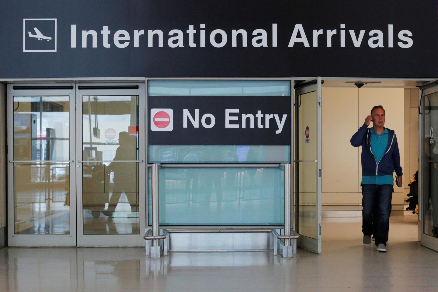International travelers arrive on the day that U.S. President Donald Trump's limited travel ban, approved by the U.S. Supreme Court, goes into effect, at Logan Airport in Boston