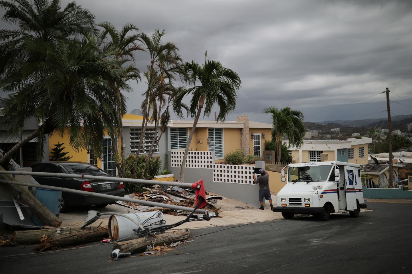 Alfredo Martinez, a mail man for the U.S. Postal Service delivers the mail at an area damaged by Hurricane Maria in San Juan, Puerto Rico