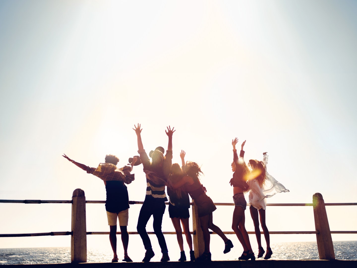 Group of hipster friends celebrating their vacations at the beach