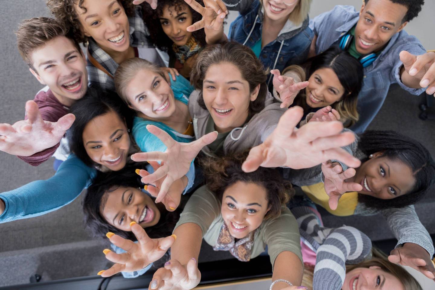 High angle view of group of college students reaching up
