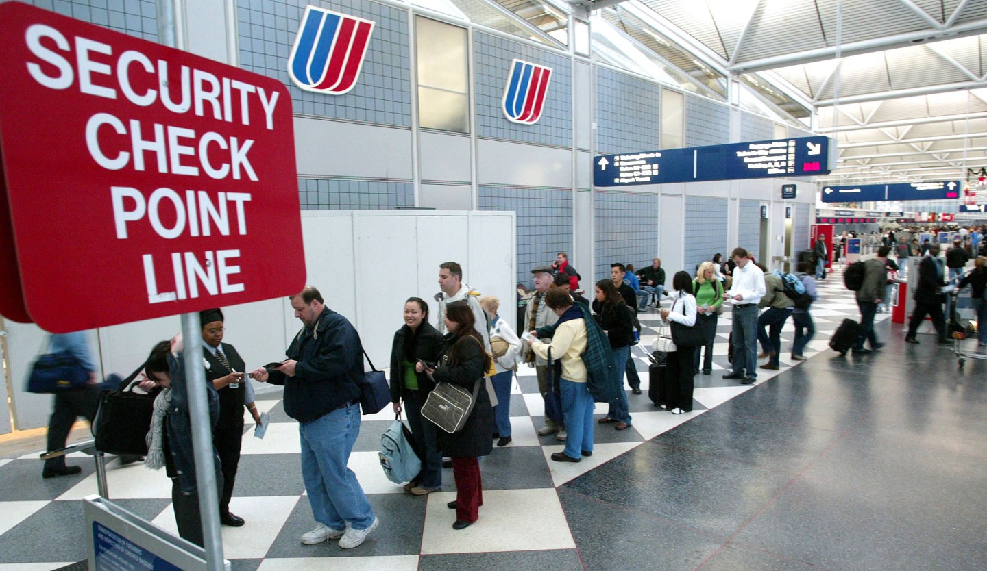 Thanksgiving travelers line up to go though a security check