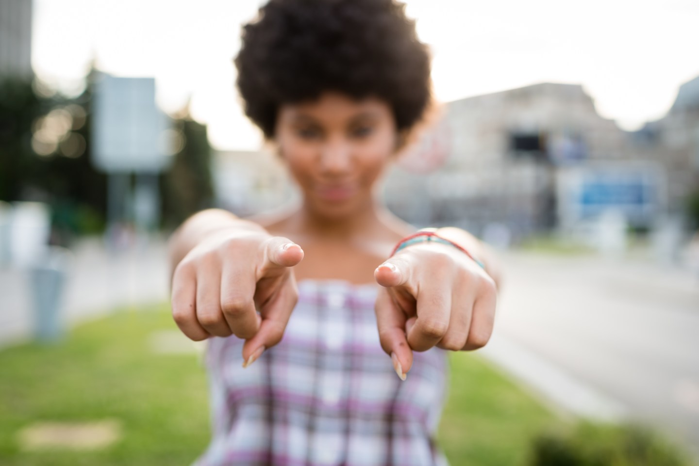 Curly haired girl pointing you out. Hazy effect.
