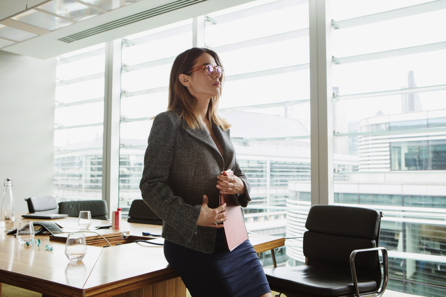 Businesswoman clutching folder, London, UK