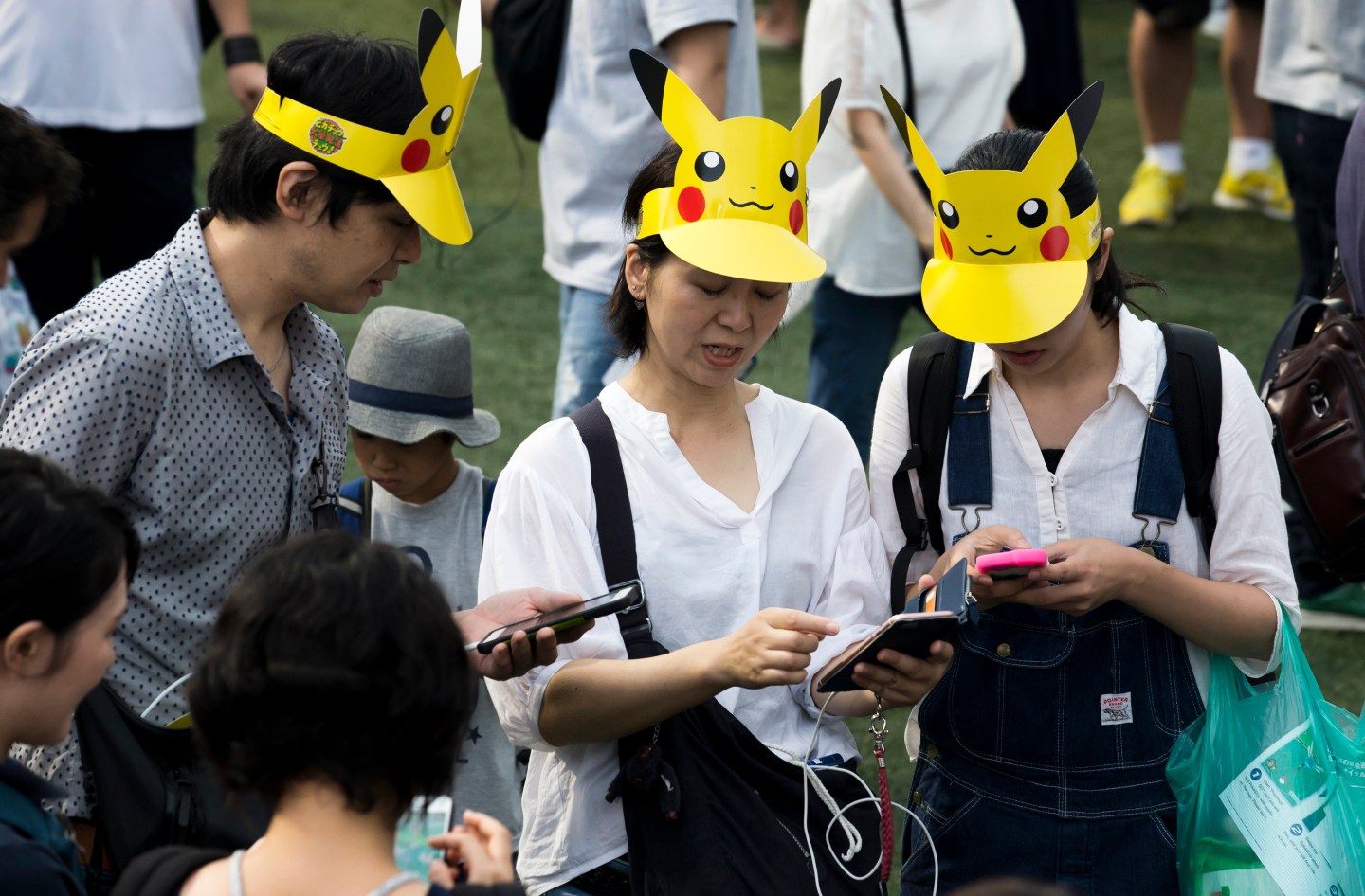 People wearing Pikachu caps play Pokemon Go in Japan