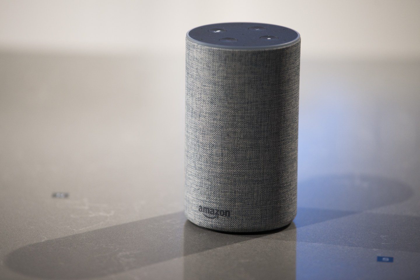 Amazon Echo sits on a table casting a shadow