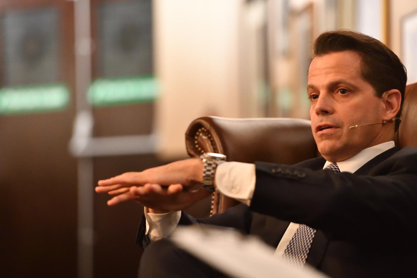 Anthony Scaramucci extends his hands while seated at the Cambridge Union