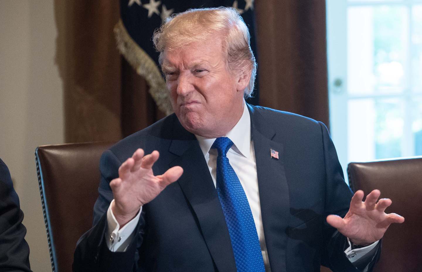 Donald Trump spreads his hands and scrunches his face