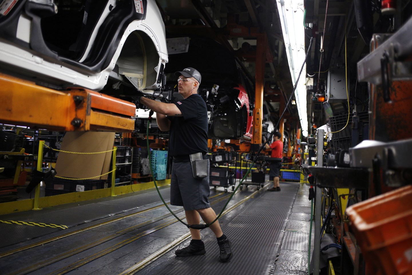 A Nissan factory worker works on a car
