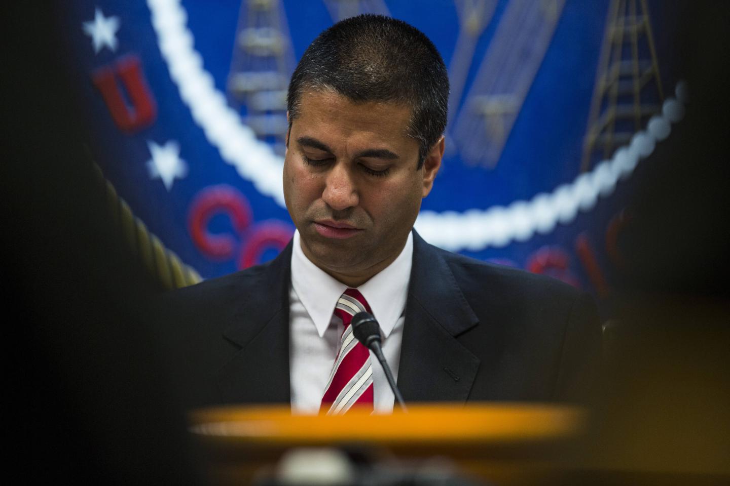 FCC Chairman Ajit Pai looks down during a meeting in Washington, DC