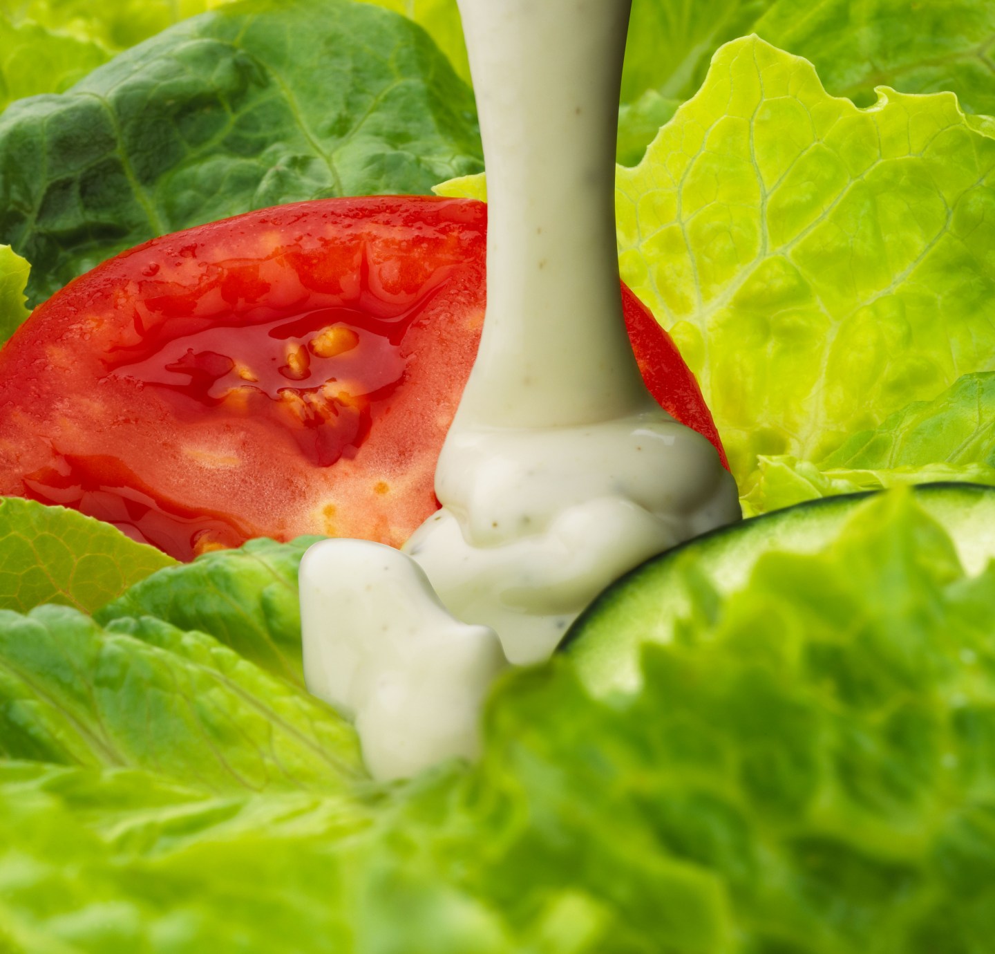 Ranch dressing pouring on salad