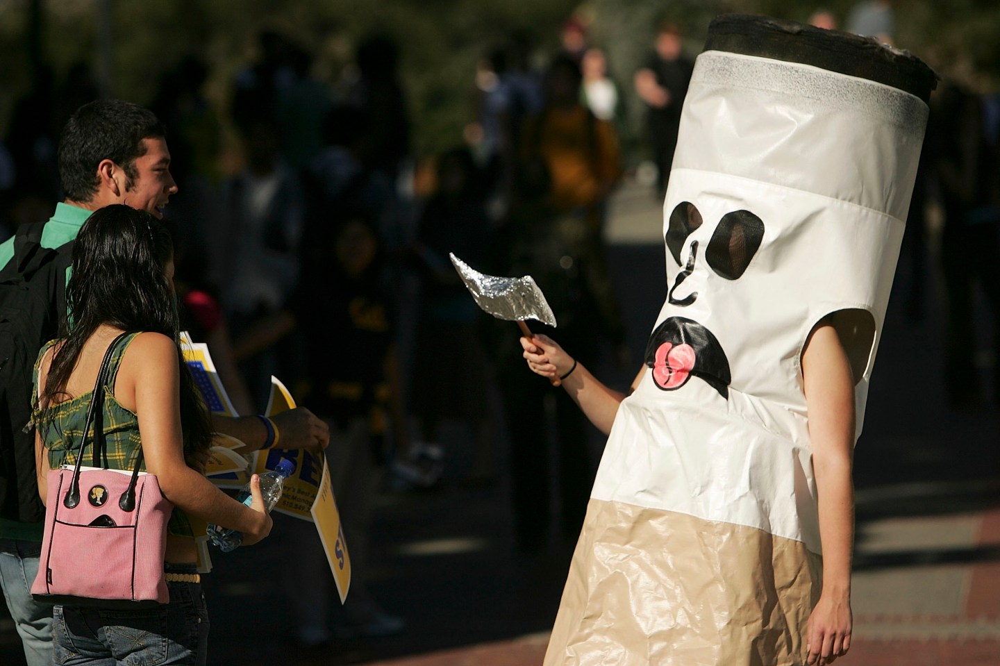 A person dressed as a cigarette encourages students to quit smoking.