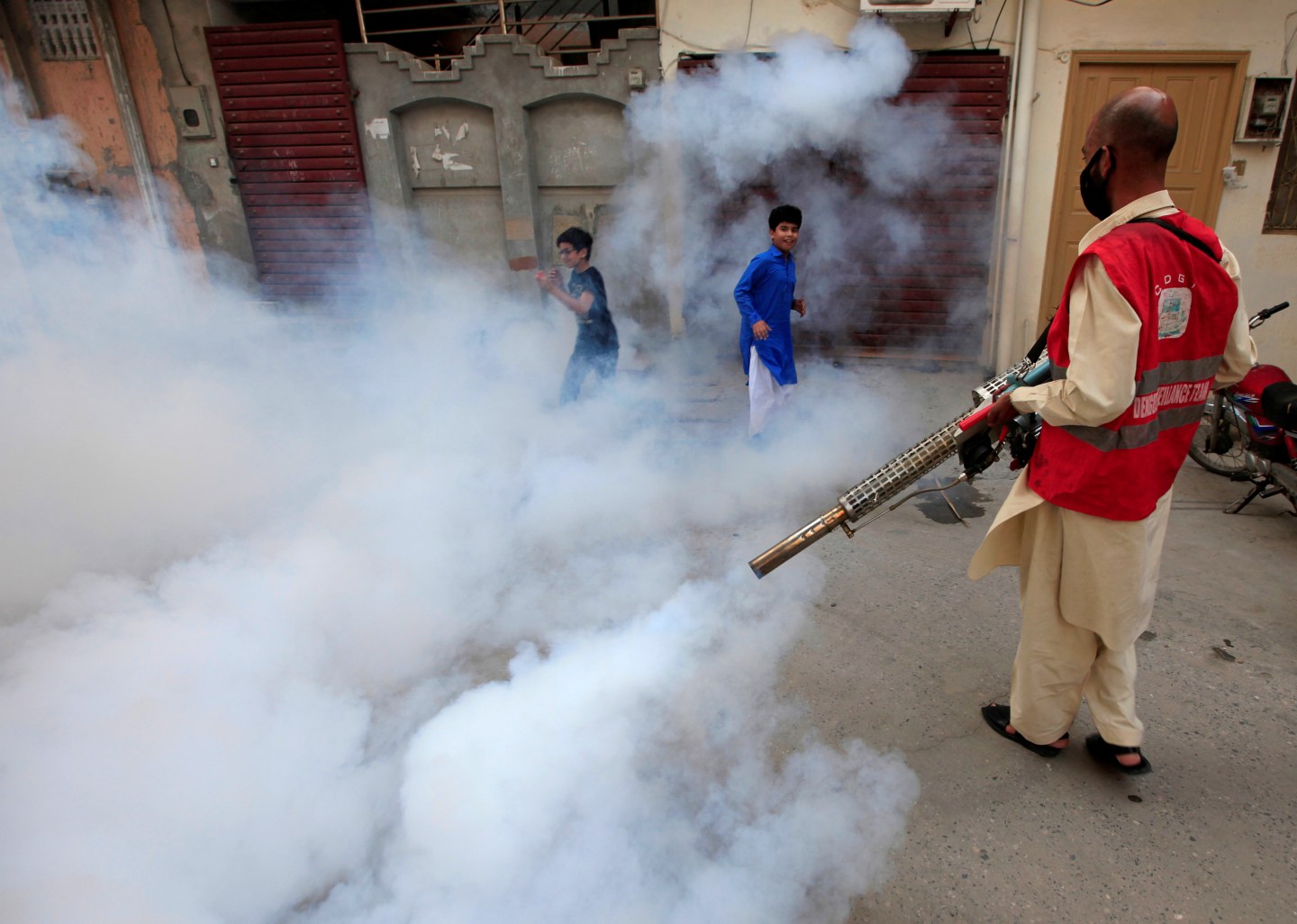 A municipal worker fumigates a street to prevent the spread of dengue fever and other mosquito-borne diseases in Rawalpindi