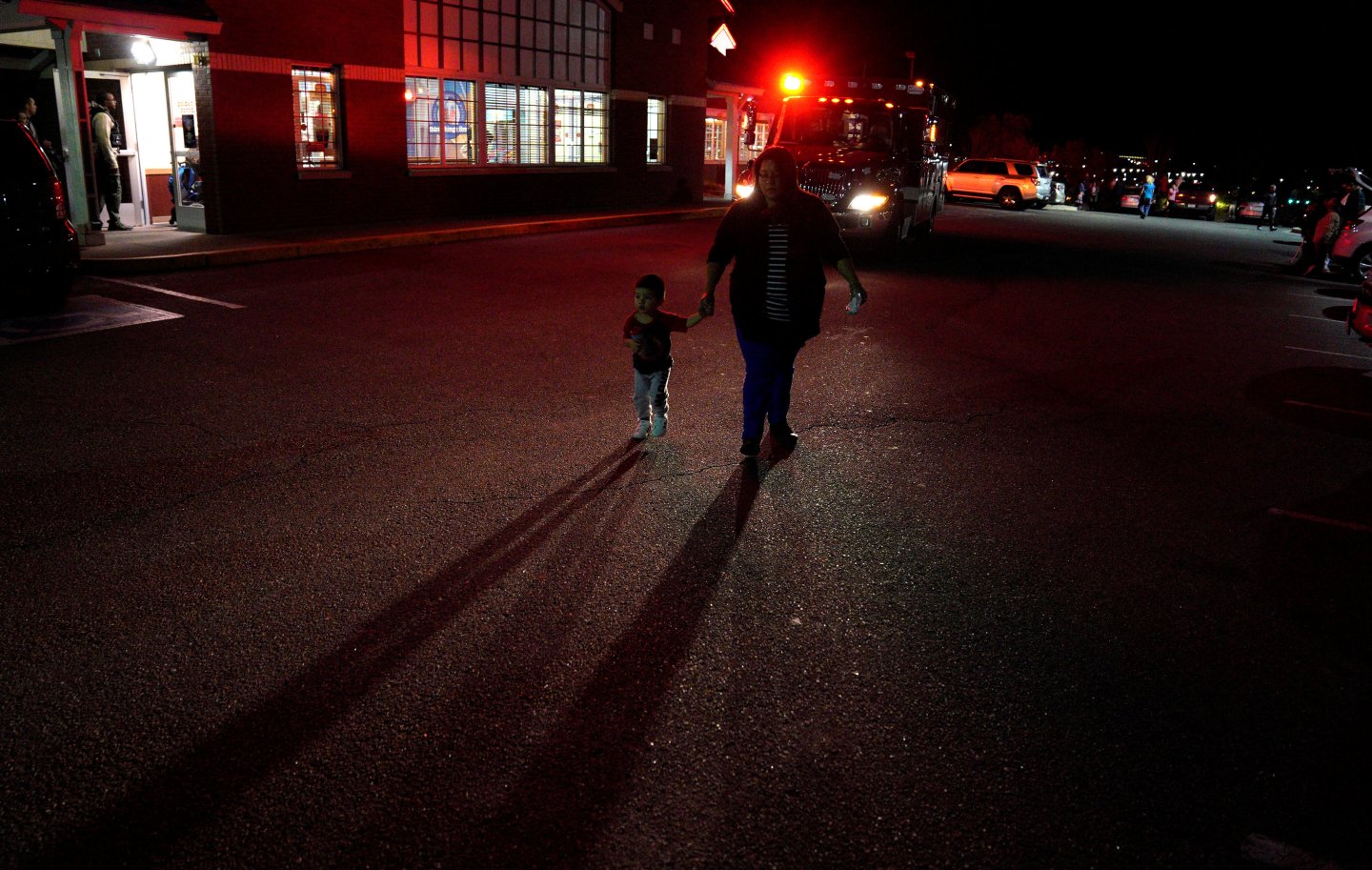 A woman walks past an ambulance near the scene of a shooting at a Walmart in Thornton, Colorado