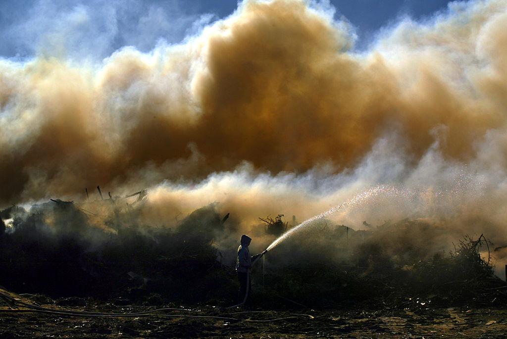 Chino. Nov. 29, 2004.  Jose Ramirez (Cq) 28, douses smoldering green waste on Monday morning fir